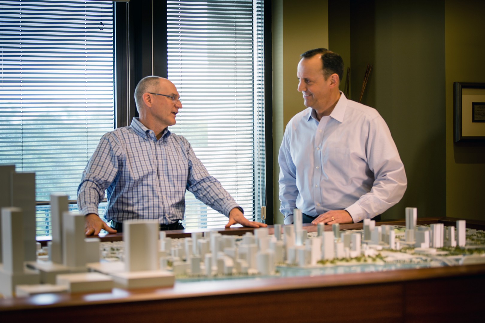 Michael Reininger and Dave Howard discuss Brightline in front of a scale model of Downtown Miami.