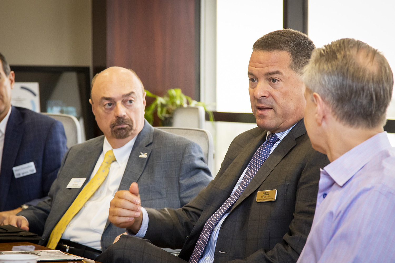 Broward County Commissioner Michael Udine, center, make a point as Ron Drew of the Alliance, left, and Will Fleming listen.
