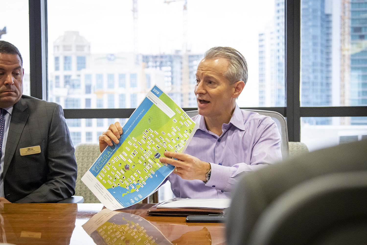 MotionPoint CEO Will Fleming holds a TechGateway map, which provides a visual reference to the abundance of tech firms in South Florida