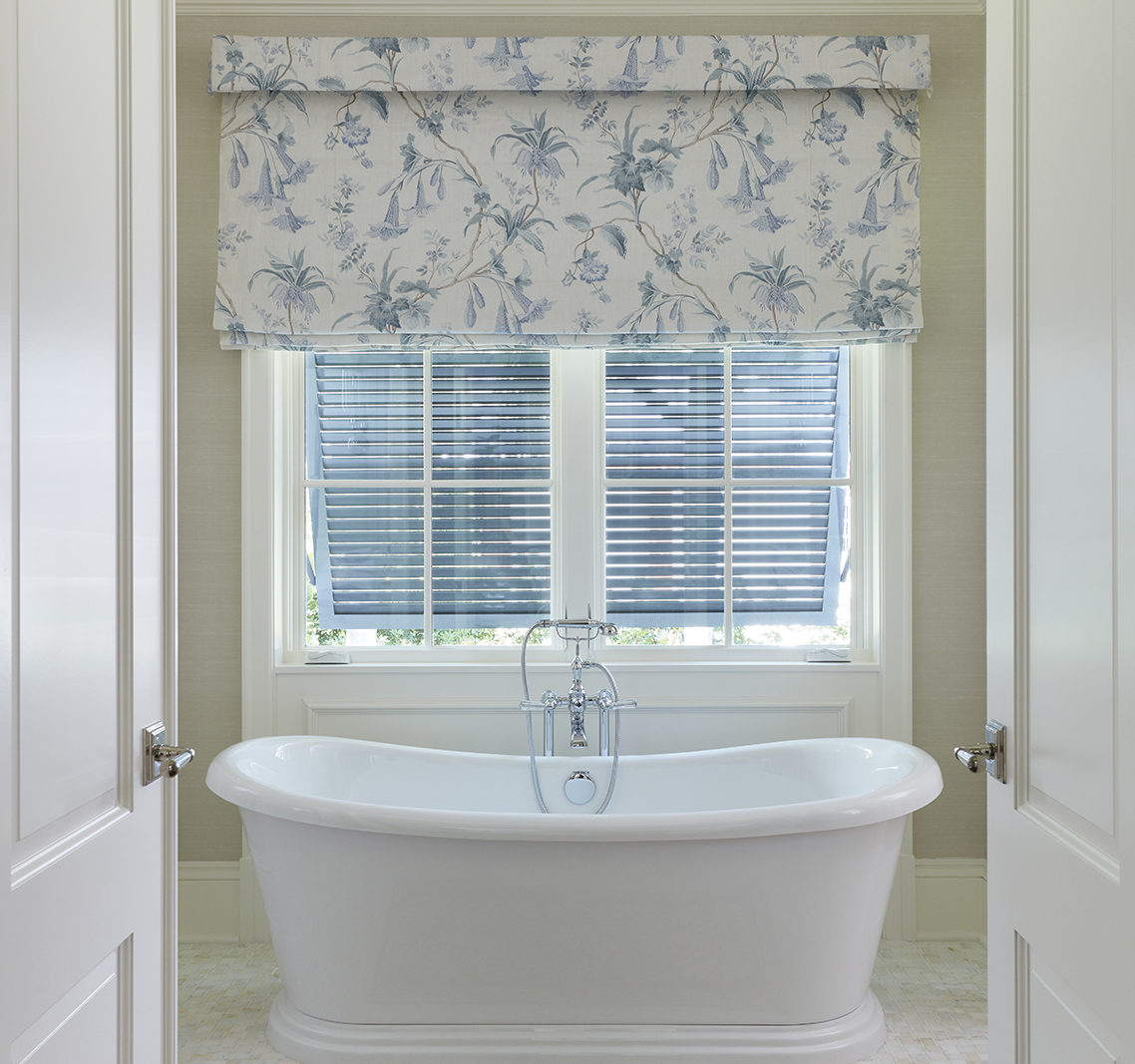 The transitional—trending toward traditional—master bathroom is anchored by a deep soaking Kohler tub